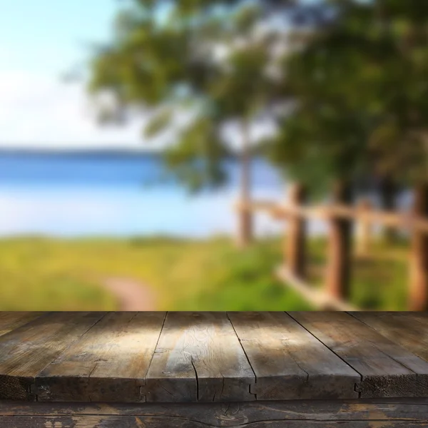Mesa de madera vintage frente al paisaje del lago bosque de ensueño y abstracto con destello de lente . — Foto de Stock