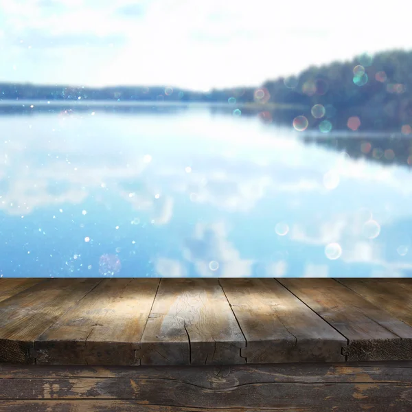 Винтажный деревянный стол перед сказочным и абстрактным лесным пейзажем озера с бликом объектива . — стоковое фото