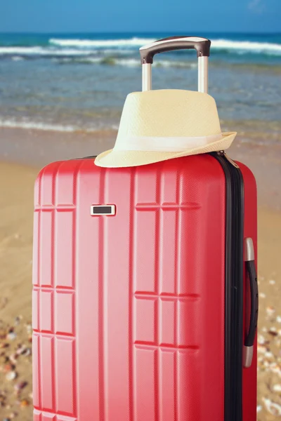 Afbeelding van rode elegante reizen bagage en fedora hoed aan zee. reizen en vakantie concept — Stockfoto