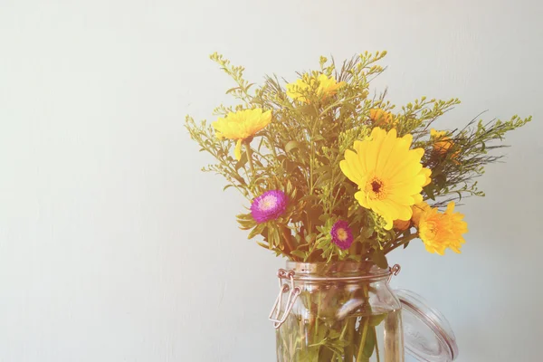 Mazzo estivo di fiori sul tavolo di legno con sfondo menta. immagine filtrata vintage — Foto Stock