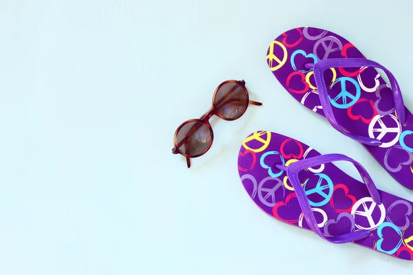 Colorful flip flops, starfish and sunglasses on wooden background — ストック写真