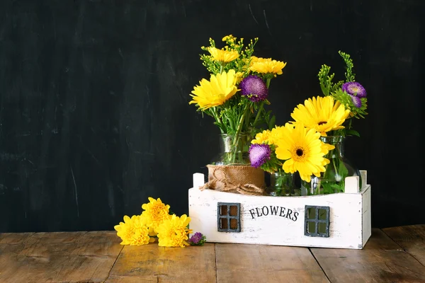 Buquê de verão de flores sobre a mesa de madeira e fundo de madeira quadro negro. espaço de cópia — Fotografia de Stock