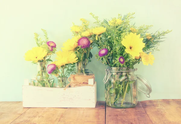 Buquê de flores de verão na mesa de madeira com fundo de hortelã. imagem filtrada vintage — Fotografia de Stock