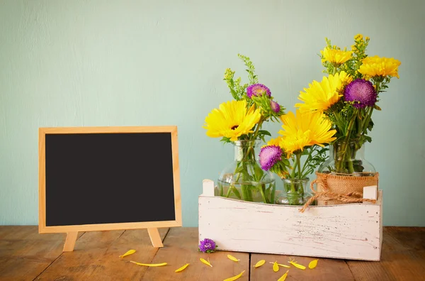 Summer bouquet of flowers and wooden blackboard on the wooden table. copy space — Stock Photo, Image