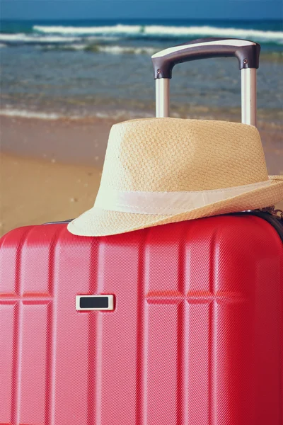 Červený zavazadla a fedora klobouk — Stock fotografie