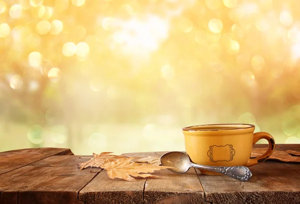 Image avant de tasse à café sur table en bois et feuilles d'automne — Photo