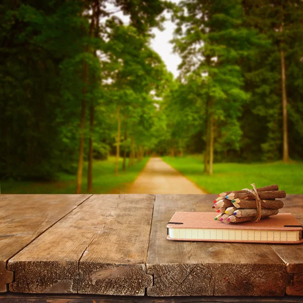 Notebook en potloden op houten tafel — Stockfoto