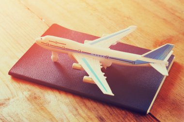 oyuncak uçak ve pasaport ahşap masa üzerinde. retro tarzı görüntü.