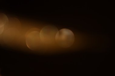 Pırıl pırıl ışıklar arka plan. Koyu altın ve siyah. Odaklanamadı.