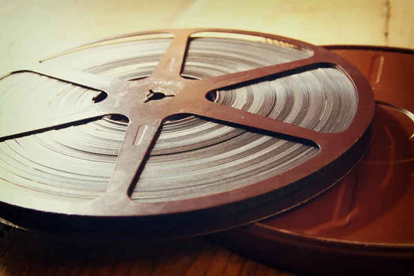 Image of old 8 mm movie reel over wooden background. retro style image. — Stock Photo, Image