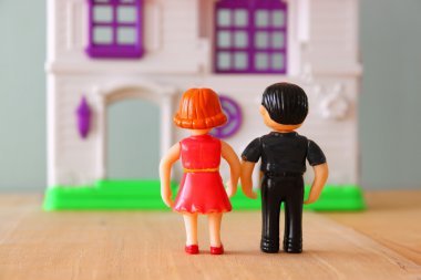 yeni evin önünde genç çift kavramı görüntüsü. küçük plastik oyuncak bebek (erkek ve dişi), seçici odak