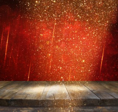 rustic wood table in front of glitter red and gold bokeh lights.