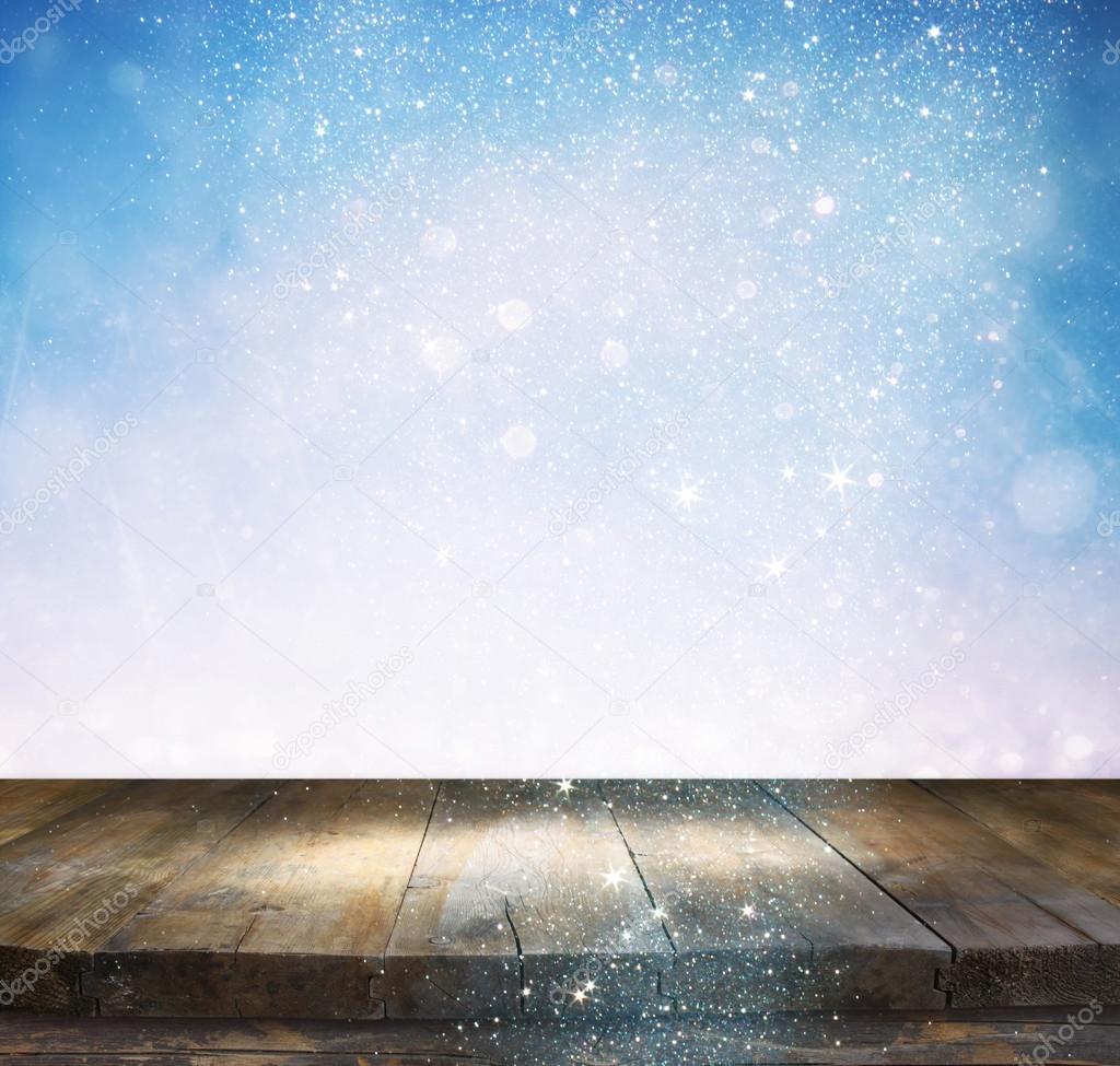 rustic wood table in front of glitter silver and white bright bokeh lights.