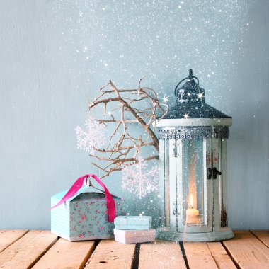 yanma ile beyaz ahşap vintage fener mum Noel hediyeleri ve ahşap masa üzerinde ağaç dalları. glitter kaplaması ile Retro filtre uygulanmış görüntü.