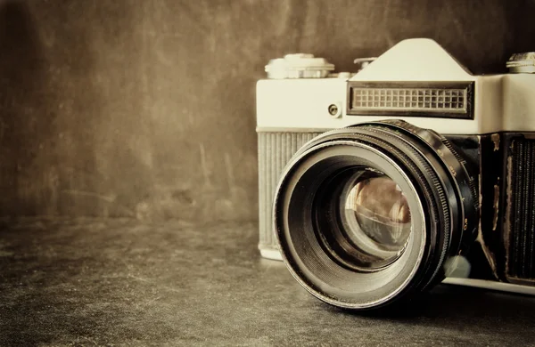Fermer la photo de l'objectif vieil appareil photo sur une table en bois. image est rétro filtrée. focus sélectif. — Photo