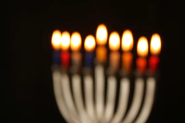 Fondo borroso abstracto de vacaciones judías fondo de Hanukkah con menorah (candelabros tradicionales) Velas ardientes sobre fondo negro . — Foto de Stock