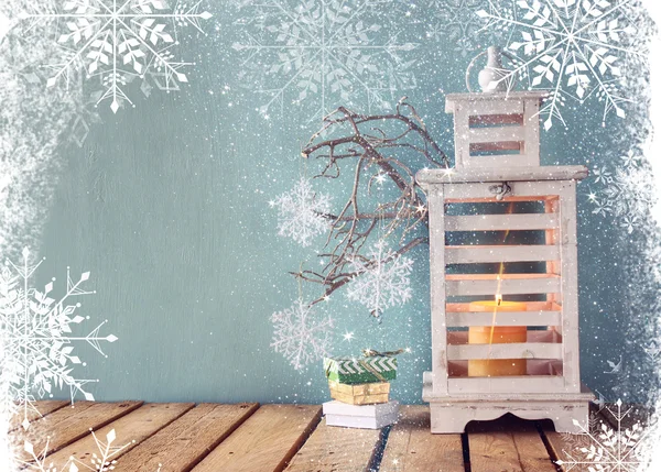 Linterna vintage de madera blanca con vela encendida, regalos de Navidad y ramas de árbol en la mesa de madera. imagen filtrada retro . —  Fotos de Stock