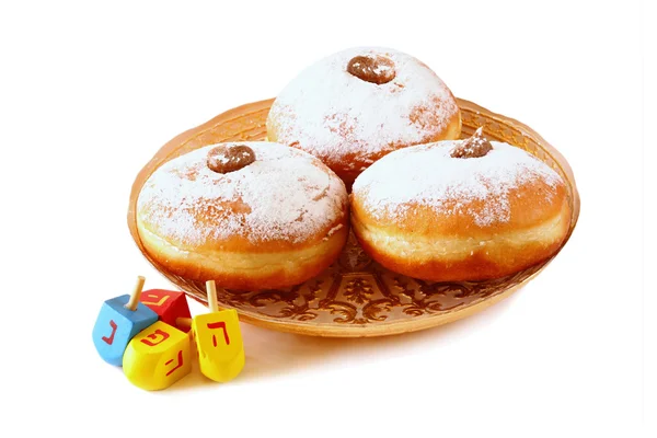 Image of jewish holiday Hanukkah with donuts and wooden dreidels (spinning top). isolated on white. — Stockfoto