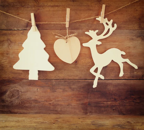 Изображение деревянной декоративной елки и оленя, висящего на веревке на деревянном фоне . — стоковое фото