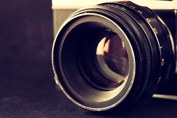 Fermer la photo de l'objectif vieil appareil photo sur une table en bois. image est rétro filtrée. focus sélectif. — Photo