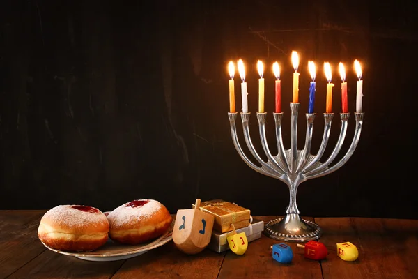 Imagem de férias judaicas Hanukkah com menorah (Candelabra tradicional), rosquinhas e dreidels de madeira (topo de giro). imagem retro filtrada . — Fotografia de Stock