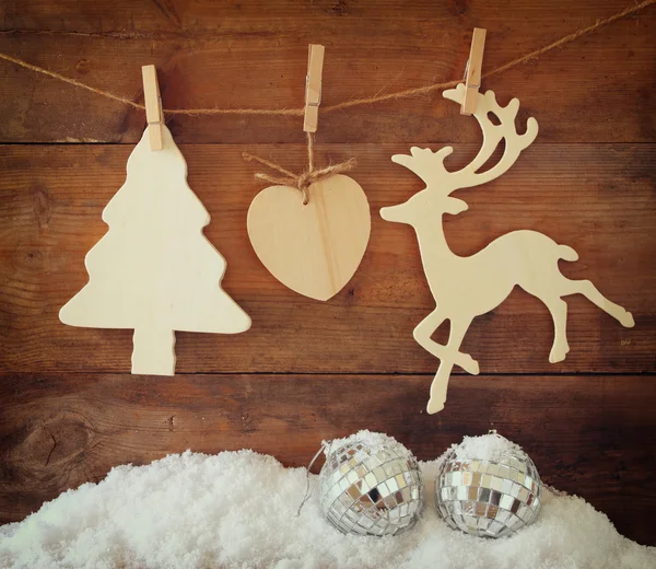 Imagen de árbol de Navidad decorativo de madera y renos colgando de una cuerda sobre un fondo de madera . —  Fotos de Stock