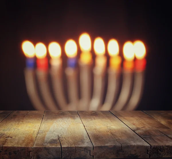 Wizerunek żydowskiego święta Chanuka tło z menory (tradycyjne Świeczniki) palenie świec i drewnianym stołem. — Zdjęcie stockowe