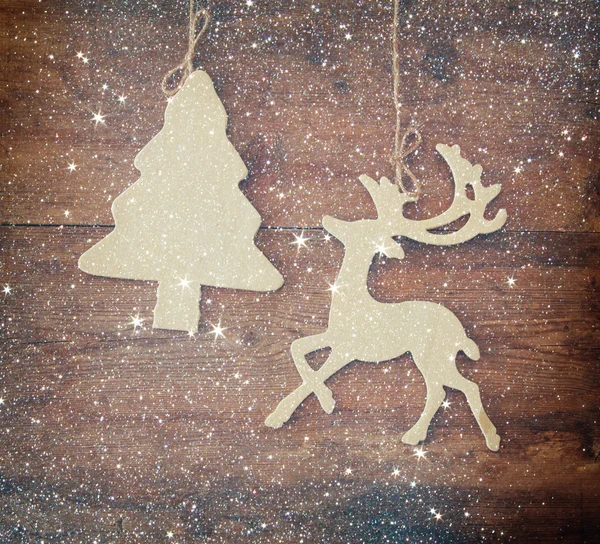 Image of wooden decorative christmas tree and reindeer hanging on a rope over wooden background. — Stock Photo, Image