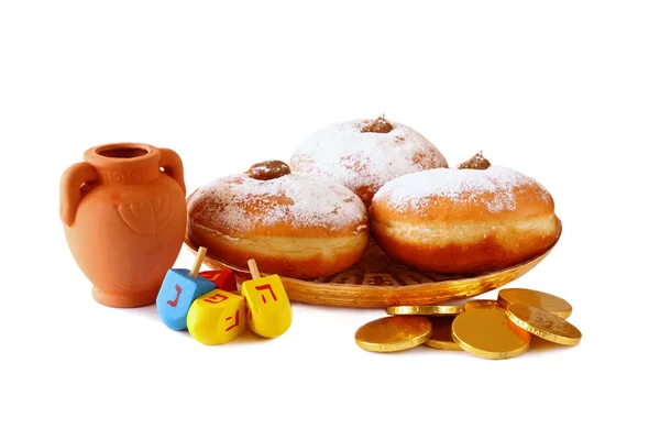 Bild des jüdischen Feiertags Chanukka mit Donuts, traditionellen Schokoladenmünzen und hölzernen Dreideln (Kreisel). isoliert auf weiß. — Stockfoto