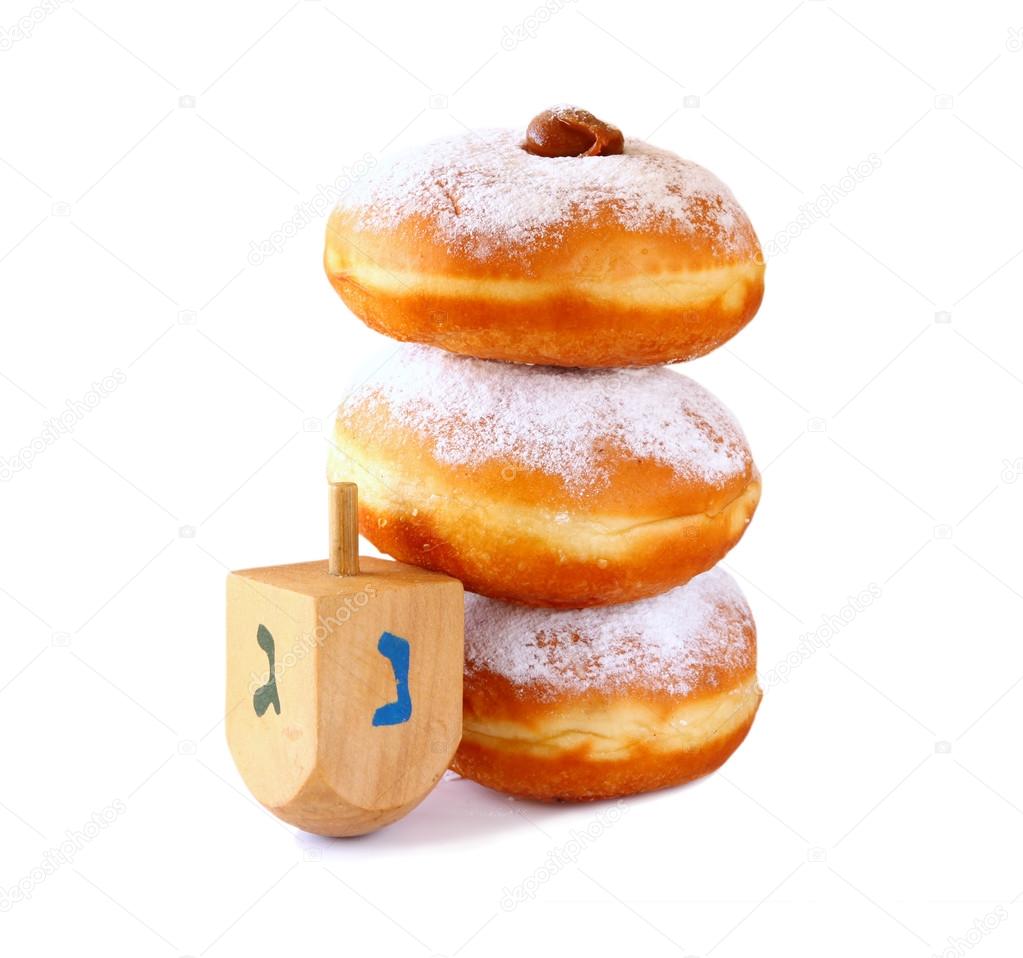 image of jewish holiday Hanukkah with donuts and wooden dreidel (spinning top). isolated on white.
