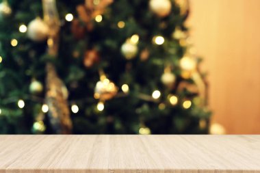 Bulanık Noel ağacının arkaplanı ve model için boş bir masa