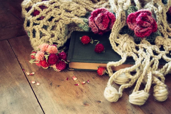 Imagen de flores secas, bufanda caliente y viejo libro vintage sobre mesa de madera. imagen filtrada retro . —  Fotos de Stock