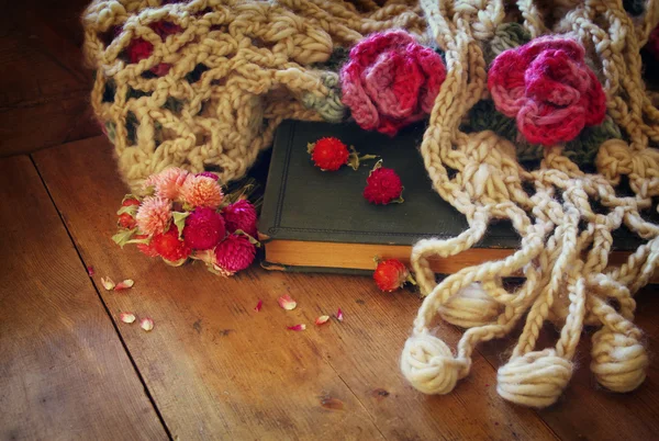 Obraz suche kwiaty, ciepły szalik i stary sztuka książki na drewnianym stole. retro filtrowanego obrazu. — Zdjęcie stockowe