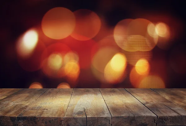 Image of wooden table in front of abstract blurred background of city lights. — 图库照片