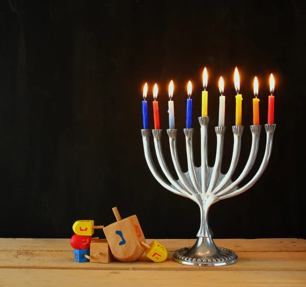 Imagem de férias judaicas Hanukkah com menorah (Candelabra tradicional) e dreidels de madeira (topo de fiação). imagem retro filtrada . — Fotografia de Stock