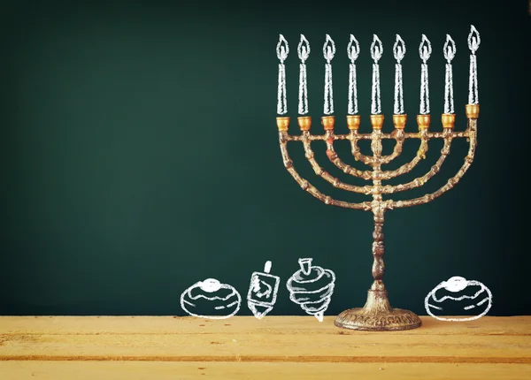Yahudi tatil Hanukkah menorah mumlar (geleneksel Mumluk), çörek ve sevinçler (iplik üst) kara tahta arka plan üzerinde çizim ile görüntü. — Stok fotoğraf