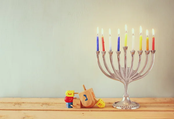 Bild av judiska högtiden Hanukkah menorah (traditionella kandelabrar) och trä dreidels (spinning överst). retro filtrerade bilden. — Stockfoto