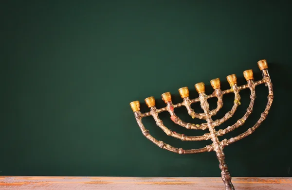 image of jewish holiday Hanukkah with menorah (traditional Candelabra) over chalkboard background, room for text.