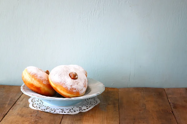ユダヤ人の休日の木製のテーブルにドーナツとハヌカのイメージ. — ストック写真