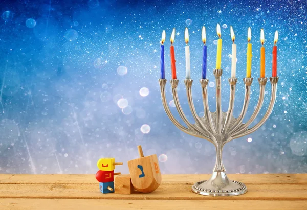 image of jewish holiday Hanukkah with menorah (traditional Candelabra) and wooden dreidels (spinning top). retro filtered image.