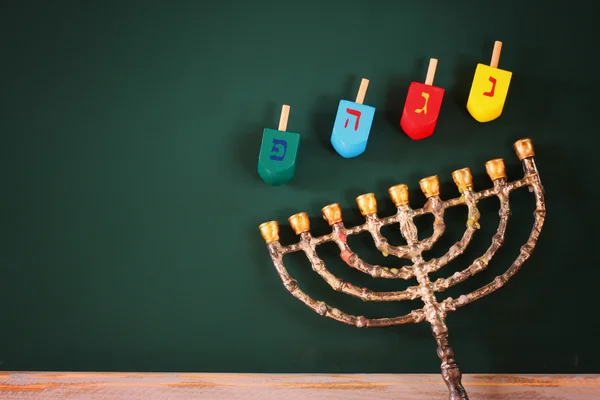 Yahudi tatil Hanukkah menorah (geleneksel Mumluk) ve ahşap renkli sevinçler (iplik üst) üzerinden kara tahta arka plan ile görüntü. — Stok fotoğraf