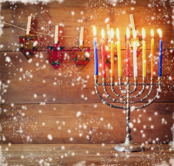 Image of jewish holiday Hanukkah background with menorah (traditional candelabra) and Burning candles. abstract snow overlay.