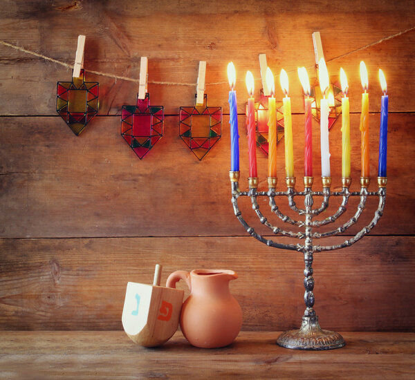 low key image of jewish holiday Hanukkah with menorah (traditional Candelabra) and wooden dreidels (spinning top) .