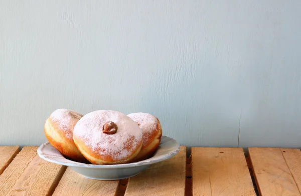 Imagen de fiesta judía Hanukkah con rosquillas en la mesa de madera . —  Fotos de Stock