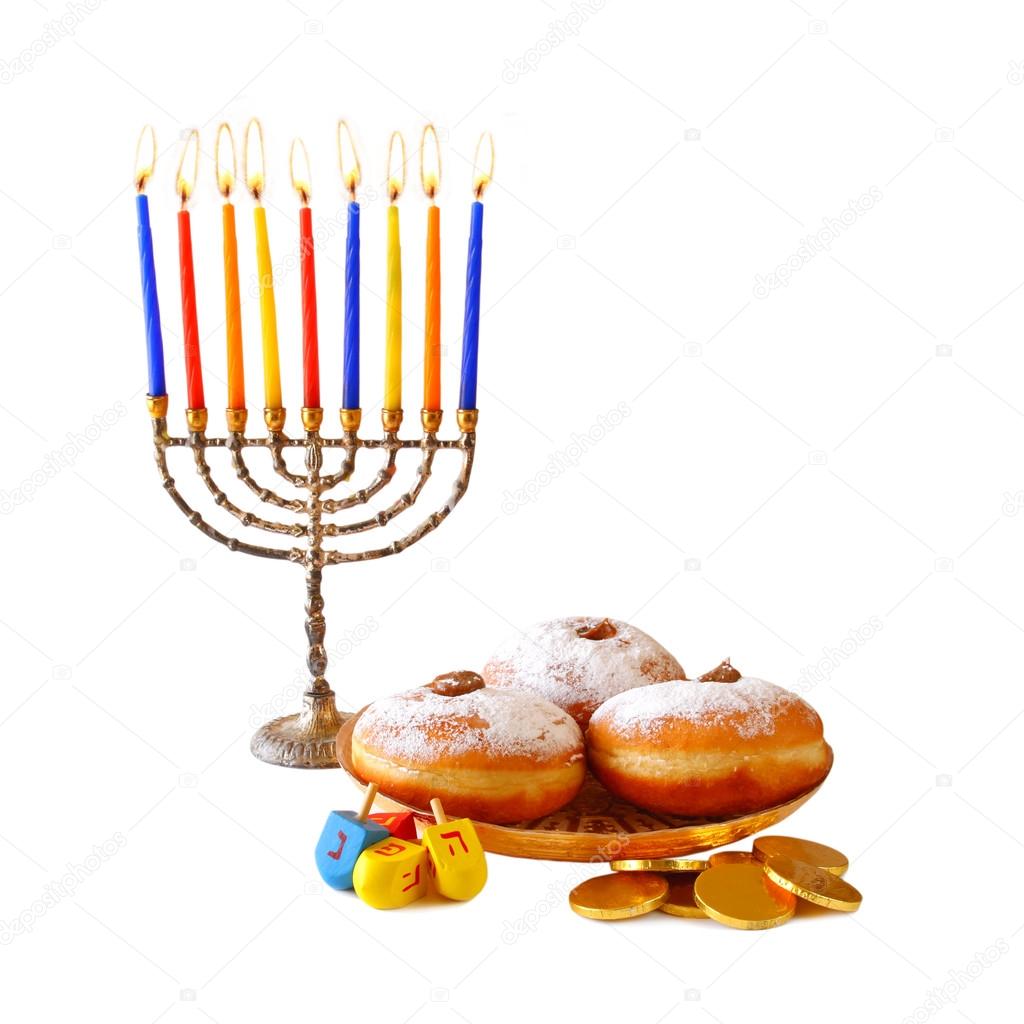 image of jewish holiday Hanukkah with menorah (traditional Candelabra), donuts and wooden dreidels (spinning top).isolated on white.