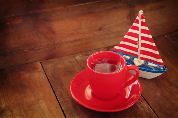 Rote Tasse Tee und dekoratives Boot . — Stockfoto