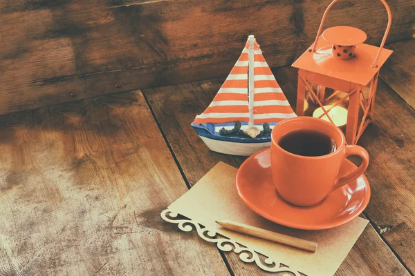 red cup of tea and decorative boat .