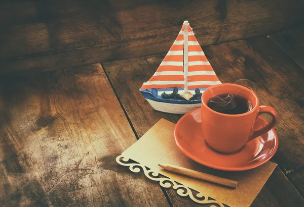 Šálek čaje a dekorativní člun — Stock fotografie