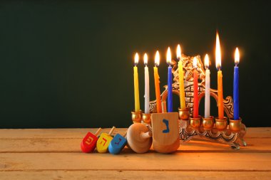 Yahudi tatil Hanukkah menorah (geleneksel Mumluk) ve ahşap sevinçler (iplik üst) ile görüntü. Retro filtre uygulanmış görüntü.