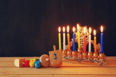 Yahudi tatil Hanukkah menorah (geleneksel Mumluk) ve ahşap sevinçler (iplik üst) ile görüntü. Retro filtre uygulanmış görüntü.